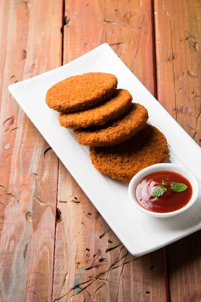 Hint sohbet madde aloo veya aalu tikki veya tikiya veya ragda köftesi ile domates ketçap, seçici odak hizmet olarak da bilinen kızarmış patates kek