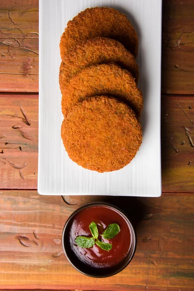 Hint sohbet madde aloo veya aalu tikki veya tikiya veya ragda köftesi ile domates ketçap, seçici odak hizmet olarak da bilinen kızarmış patates kek