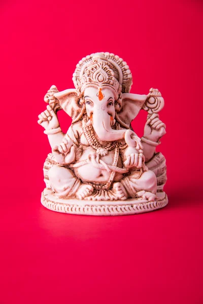 Statue of Ganesha Idol made of white marbal on plain bright red background. Clear space for text or headline — Stock Photo, Image