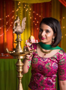 Hint genç ve güzel kız geleneksel giyim aydınlatma yağ lambası veya diya ile samai ve ganesh festivali veya Diwali veya deepavali kutluyor. Hintli kız elleri kapalı yağ lambası tutarak.