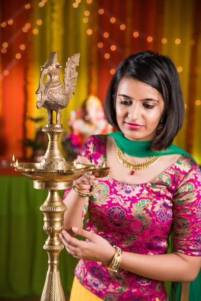 Indiano giovane e bella ragazza in tradizionale usura lampada ad olio di illuminazione o samai con diya e celebrare festa ganesh o Diwali o deepavali. Indiano ragazza mani tenendo olio lampada al coperto . — Foto Stock