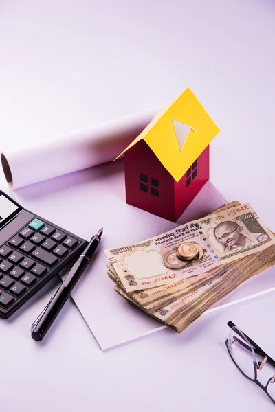 Comprar casa en préstamo o concepto de alquiler utilizando casa modelo, calculadora, billetes de moneda india, bolígrafo y gafas —  Fotos de Stock