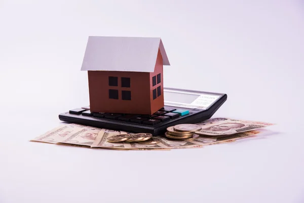 Acquisto di casa in prestito o in affitto concetto utilizzando casa modello, calcolatrice, banconote in valuta indiana, penna e occhiali — Foto Stock