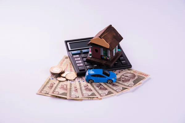 Acquisto di casa e auto concetto, banconote in valuta indiana, casa modello, chiavi, giocattolo auto e calcolatrice, isolato — Foto Stock