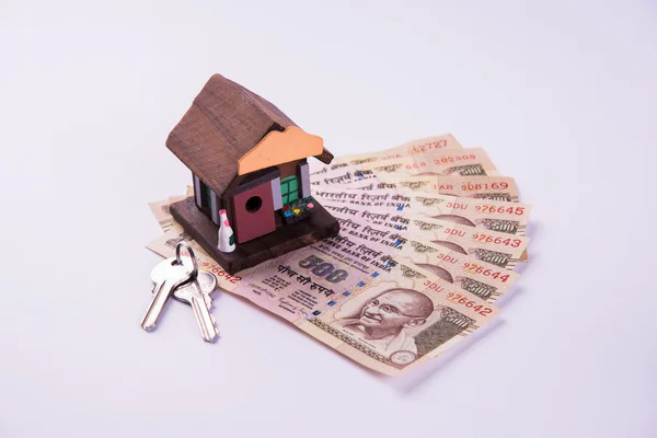 Acheter une maison sur prêt ou louer concept en utilisant la maison modèle, calculatrice, billets de monnaie indienne, stylo et lunettes — Photo