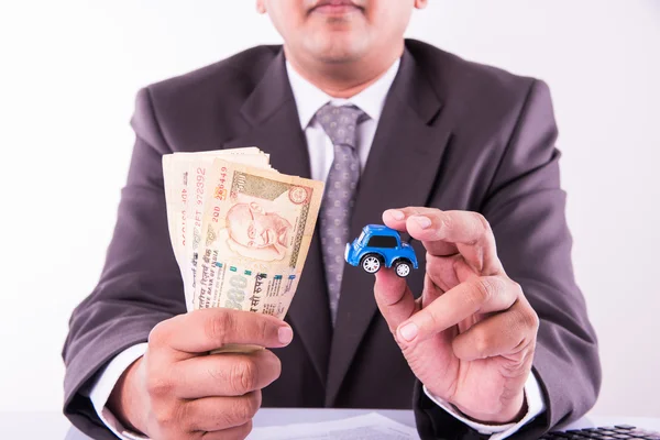 Indyjski biznesmen gospodarstwa notatki walutowe i samochód Zabawka z kluczem, zakup koncepcji samochodu — Zdjęcie stockowe