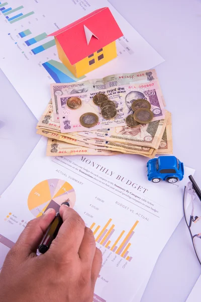 Hombre indio o contable persona que presenta formulario de declaración de impuestos indio o documento ITR que muestra moneda india, modelo de casa, coche de juguete y calculadora sobre mesa blanca, enfoque selectivo — Foto de Stock