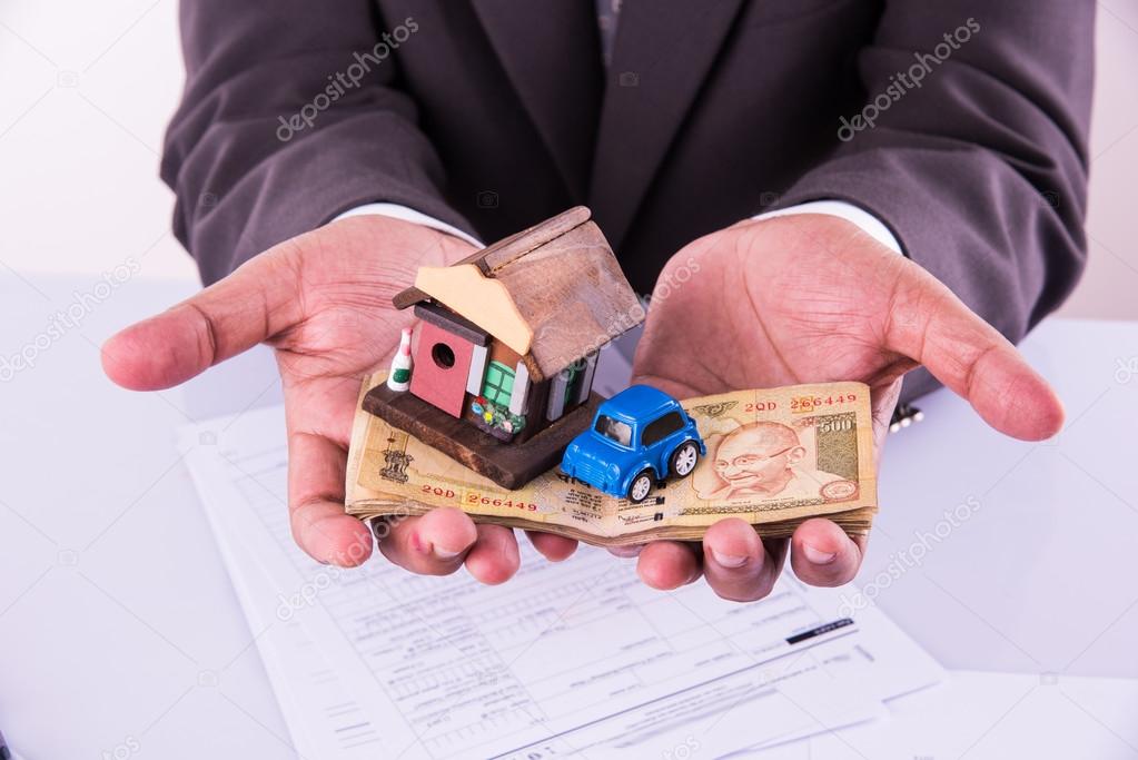 Home And Car Buying Concept Indian Man Holding Indian Currency In Both Hands And Model House And Toy Car Over It Closeup And Selective Focus Stock Photo By C Stockimagefactory Com