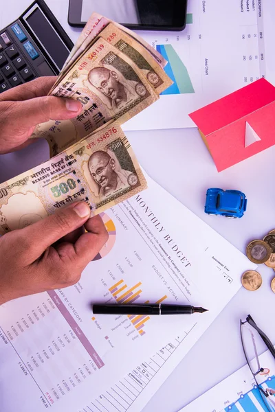 Hombre indio o contable persona que presenta formulario de declaración de impuestos indio o documento ITR que muestra moneda india, modelo de casa, coche de juguete y calculadora sobre mesa blanca, enfoque selectivo — Foto de Stock