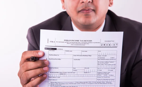 indian businessman showing indian income tax return form or ITR-4 form or form no. 16 of income tax department of india, selective focus