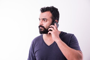 sakallı ve bıyıklı hipster hint genç adam akıllı telefon kullanarak meşgul, beyaz arka plan üzerinde izole