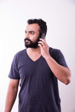 sakallı ve bıyıklı hipster hint genç adam akıllı telefon kullanarak meşgul, beyaz arka plan üzerinde izole