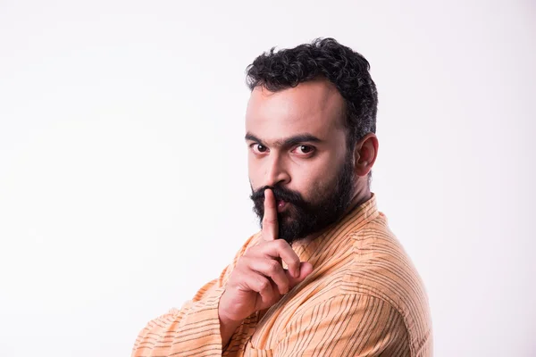 Hombre barbudo indio mostrando guardar silencio signo, joven indio con barba mantener el dedo en los labios pidiendo silencio —  Fotos de Stock