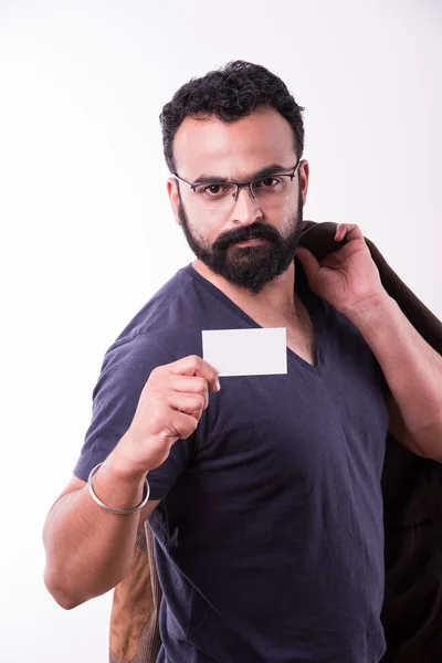 Jovem indiano hipster com barba e bigode exibindo cartão de visita vazio. feliz sorriso jovem bonito asiático cara desgaste camisa isolado branco fundo — Fotografia de Stock