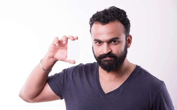 Hipster Indiase jonge man met baard en snor weergeven lege lege visitekaartje. Gelukkig glimlach jonge knappe Aziatische kerel dragen shirt geïsoleerd witte achtergrond — Stockfoto