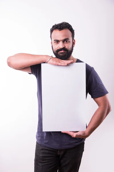 Porträtt av stilig indisk man med skägg hållande vit blank bräda. Indisk man håller blank affisch. — Stockfoto