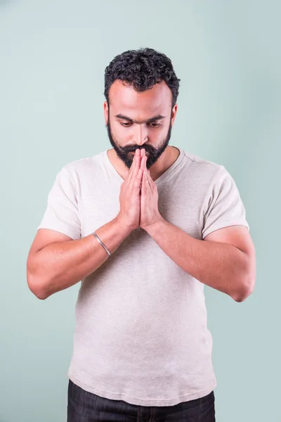 Indický mladý muž dotýkal se bradě zeleného pozadí — Stock fotografie