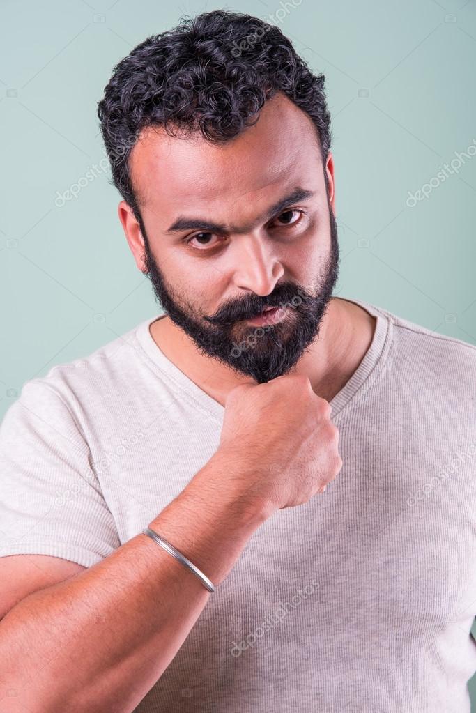 Indian young man touching beard - green background Stock Photo by  © 122997964
