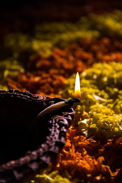 Traditional diya or oil lamp lit on colorful rangoli made up of flower petal, on the festival of lights called diwali or deepawali, selective focus