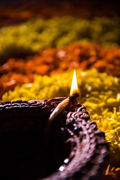 Lampe à huile ou diya traditionnelle allumée sur des rangoli colorés composés de pétales de fleurs, sur la fête des lumières appelée diwali ou deepawali, mise au point sélective — Photo