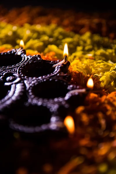 Traditionella diya eller olja lampan tänd på färgglada rangoli består av blomma kronblad, på festivalen av ljus kallas diwali eller deepawali, selektivt fokus — Stockfoto