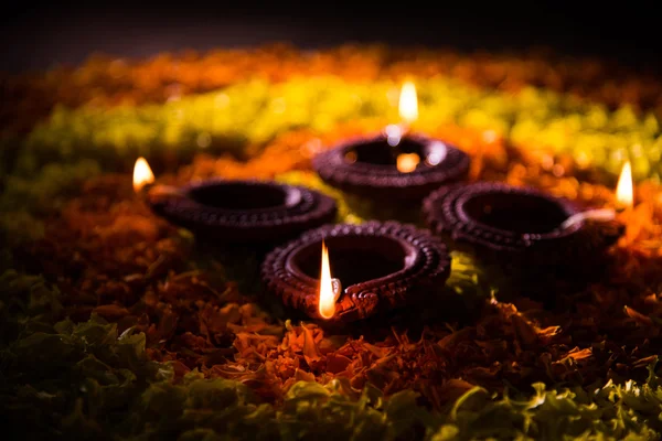 Tradicional diya o lámpara de aceite encendido en rangoli colorido compuesto de pétalo de flor, en el festival de luces llamado diwali o deepawali, enfoque selectivo —  Fotos de Stock