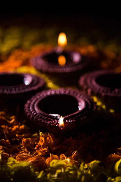 Traditionella diya eller olja lampan tänd på färgglada rangoli består av blomma kronblad, på festivalen av ljus kallas diwali eller deepawali, selektivt fokus — Stockfoto