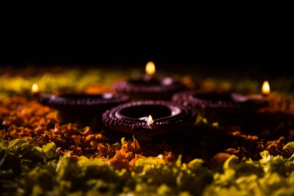 Diya tradicional ou lâmpada de óleo acesa em rangoli colorido composto de pétala de flor, no festival de luzes chamado diwali ou deepawali, foco seletivo — Fotografia de Stock