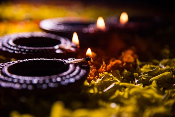 Diya tradicional ou lâmpada de óleo acesa em rangoli colorido composto de pétala de flor, no festival de luzes chamado diwali ou deepawali, foco seletivo — Fotografia de Stock