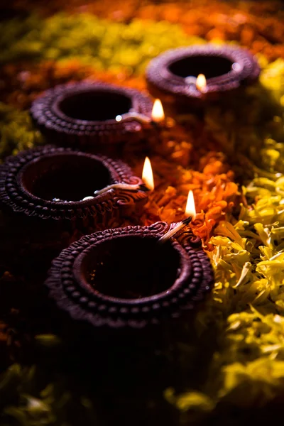 Tradicional diya o lámpara de aceite encendido en rangoli colorido compuesto de pétalo de flor, en el festival de luces llamado diwali o deepawali, enfoque selectivo —  Fotos de Stock