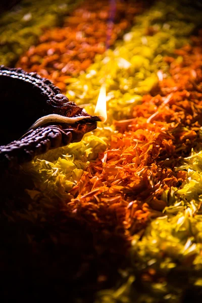 Traditionella diya eller olja lampan tänd på färgglada rangoli består av blomma kronblad, på festivalen av ljus kallas diwali eller deepawali, selektivt fokus — Stockfoto