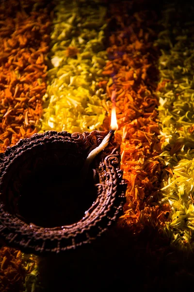 Lampe à huile ou diya traditionnelle allumée sur des rangoli colorés composés de pétales de fleurs, sur la fête des lumières appelée diwali ou deepawali, mise au point sélective — Photo