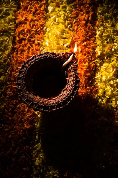 Diya tradicional ou lâmpada de óleo acesa em rangoli colorido composto de pétala de flor, no festival de luzes chamado diwali ou deepawali, foco seletivo — Fotografia de Stock