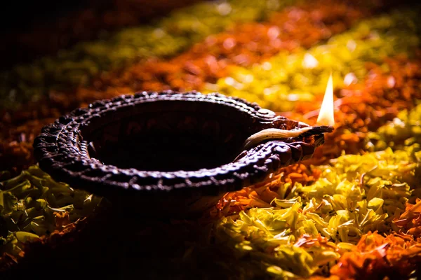 Diya tradicional ou lâmpada de óleo acesa em rangoli colorido composto de pétala de flor, no festival de luzes chamado diwali ou deepawali, foco seletivo — Fotografia de Stock