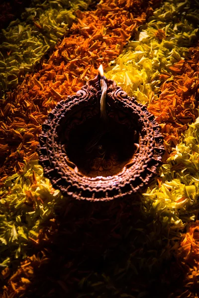 Traditionele diya of olie lampje verlicht op kleurrijke rangoli samengesteld uit bloem bloemblad, op het festival van lichten genaamd diwali of deepawali, selectieve aandacht — Stockfoto