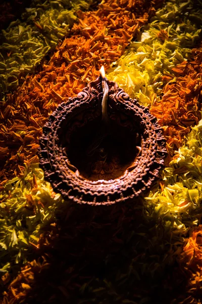 Diya tradicional ou lâmpada de óleo acesa em rangoli colorido composto de pétala de flor, no festival de luzes chamado diwali ou deepawali, foco seletivo — Fotografia de Stock