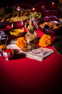 yağ lambası veya diya kraker, tatlı veya Kaymaklı, Kuru meyve, Hint para birimi notlar, kadife çiçeği çiçek ve Tanrıça Laxmi veya lakshmi diwali gecesi heykeli