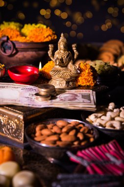 yağ lambası veya diya kraker, tatlı veya Kaymaklı, Kuru meyve, Hint para birimi notlar, kadife çiçeği çiçek ve Tanrıça Laxmi veya lakshmi diwali gecesi heykeli