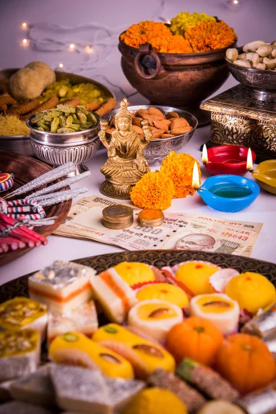 Olielamp of diya met crackers, zoet of mithai, droge vruchten, Indische bankbiljetten, Goudsbloem bloemen en standbeeld van Godin Laxmi of lakshmi op diwali nacht — Stockfoto