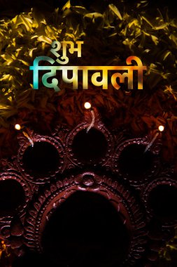 mutlu diwali tebrik kartı marigold yaprağı's rangoli üzerine yerleştirilen geleneksel bir Hint toprak lamba kullanılarak yapılan, yakın ve seçici odak