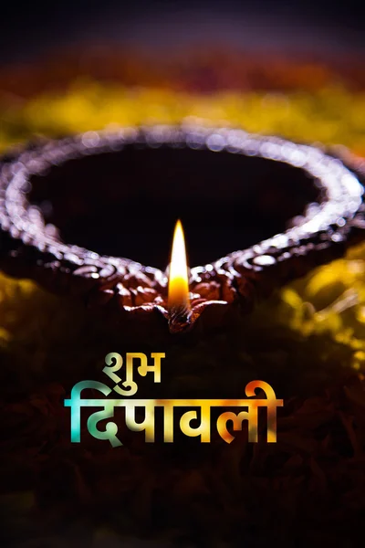 Gelukkig Diwali wenskaart gemaakt met behulp van een traditionele Indische aarden lamp geplaatst over Goudsbloem Petal Rangoli, close-up en selectieve focus — Stockfoto