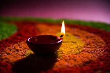 güzel diwali diya veya yağ lambası renkli pirinç tahıl, seçici odak kullanılarak yapılan rangoli yerleştirilen