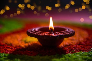 güzel diwali diya veya yağ lambası renkli pirinç tahıl, seçici odak kullanılarak yapılan rangoli yerleştirilen