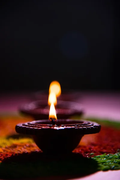 Hermosa diwali diya o lámpara de aceite colocada sobre rangoli hecho con grano de arroz de colores, enfoque selectivo —  Fotos de Stock