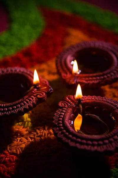 Piękne diwali diya lub oleju lampa umieszczona nad rangoli wykonane przy użyciu kolorowy ryż, Selektywny fokus — Zdjęcie stockowe