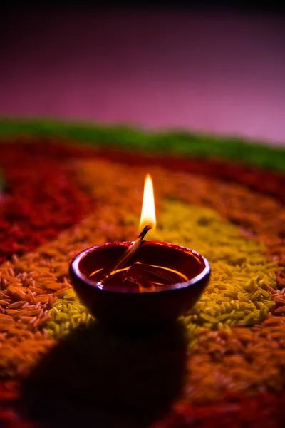 Hermosa diwali diya o lámpara de aceite colocada sobre rangoli hecho con grano de arroz de colores, enfoque selectivo — Foto de Stock