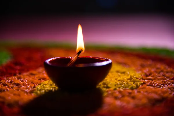 Hermosa diwali diya o lámpara de aceite colocada sobre rangoli hecho con grano de arroz de colores, enfoque selectivo — Foto de Stock