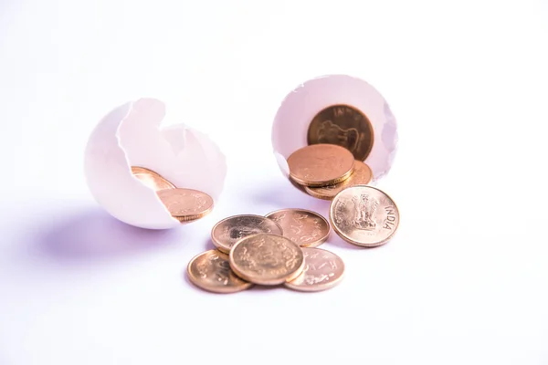 Індійські п'ять монет рупій, що виходять з тріщинного яйця, індійські рупії та тріснуте яйце, вибірковий фокус, ізольовані на білому тлі — стокове фото