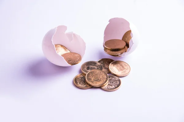 Monedas indias de cinco rupias que emergen de huevo agrietado, rupias indias y huevo agrietado, enfoque selectivo, aislado sobre fondo blanco — Foto de Stock