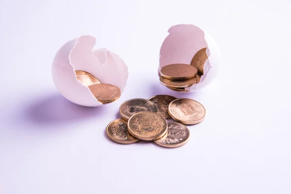 Monedas indias de cinco rupias que emergen de huevo agrietado, rupias indias y huevo agrietado, enfoque selectivo, aislado sobre fondo blanco — Foto de Stock